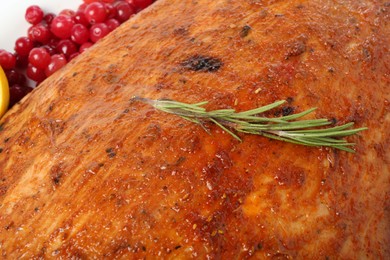 Photo of Piece of delicious baked turkey with cranberries and rosemary, closeup