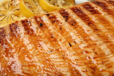 Photo of Delicious grilled turkey breast with lemon slices as background, closeup