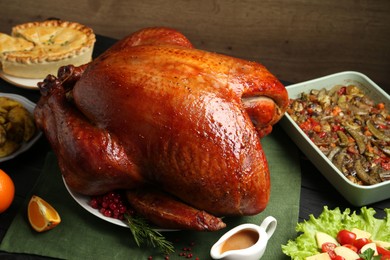 Photo of Whole baked turkey and other dishes served on table, closeup