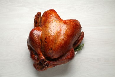 Photo of Whole baked turkey on light wooden table, top view