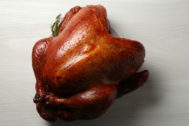 Photo of Whole baked turkey on light wooden table, top view