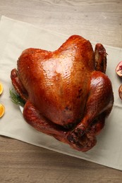 Photo of Whole baked turkey on wooden table, top view