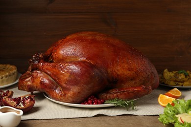 Photo of Whole baked turkey and other dishes served on wooden table