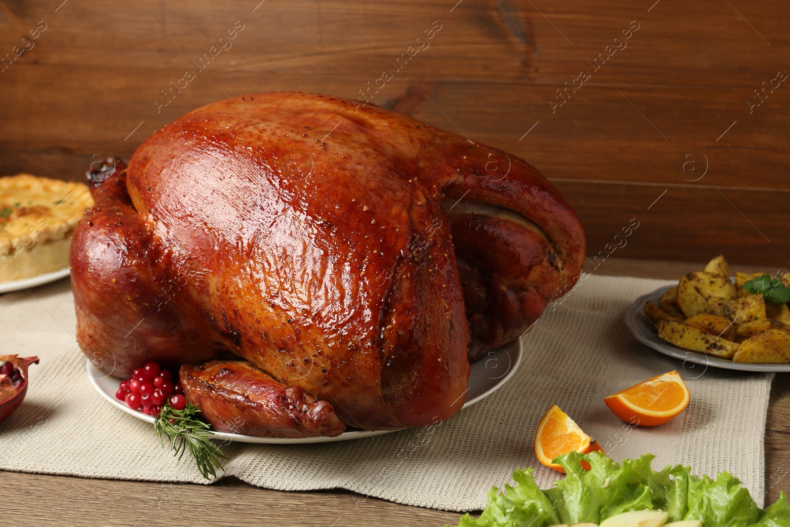 Photo of Whole baked turkey and other dishes served on wooden table