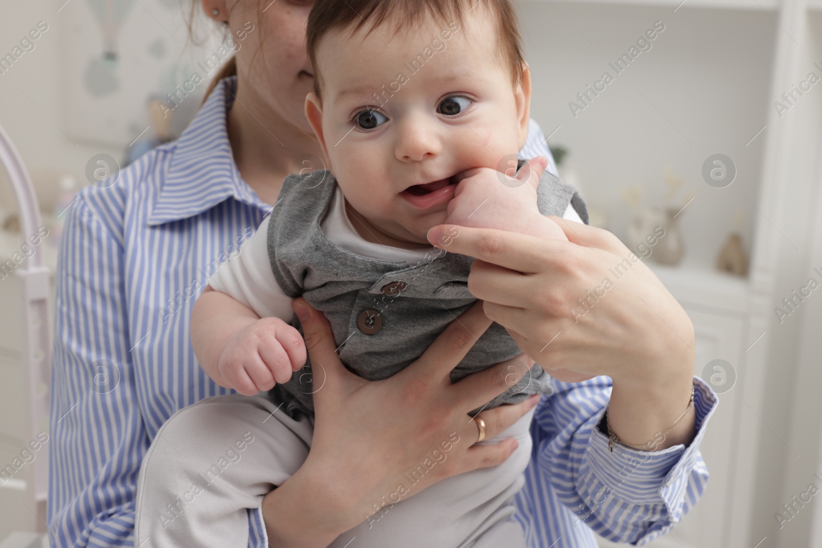 Photo of Mother holding her little baby at home, closeup