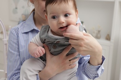 Photo of Mother holding her little baby at home, closeup