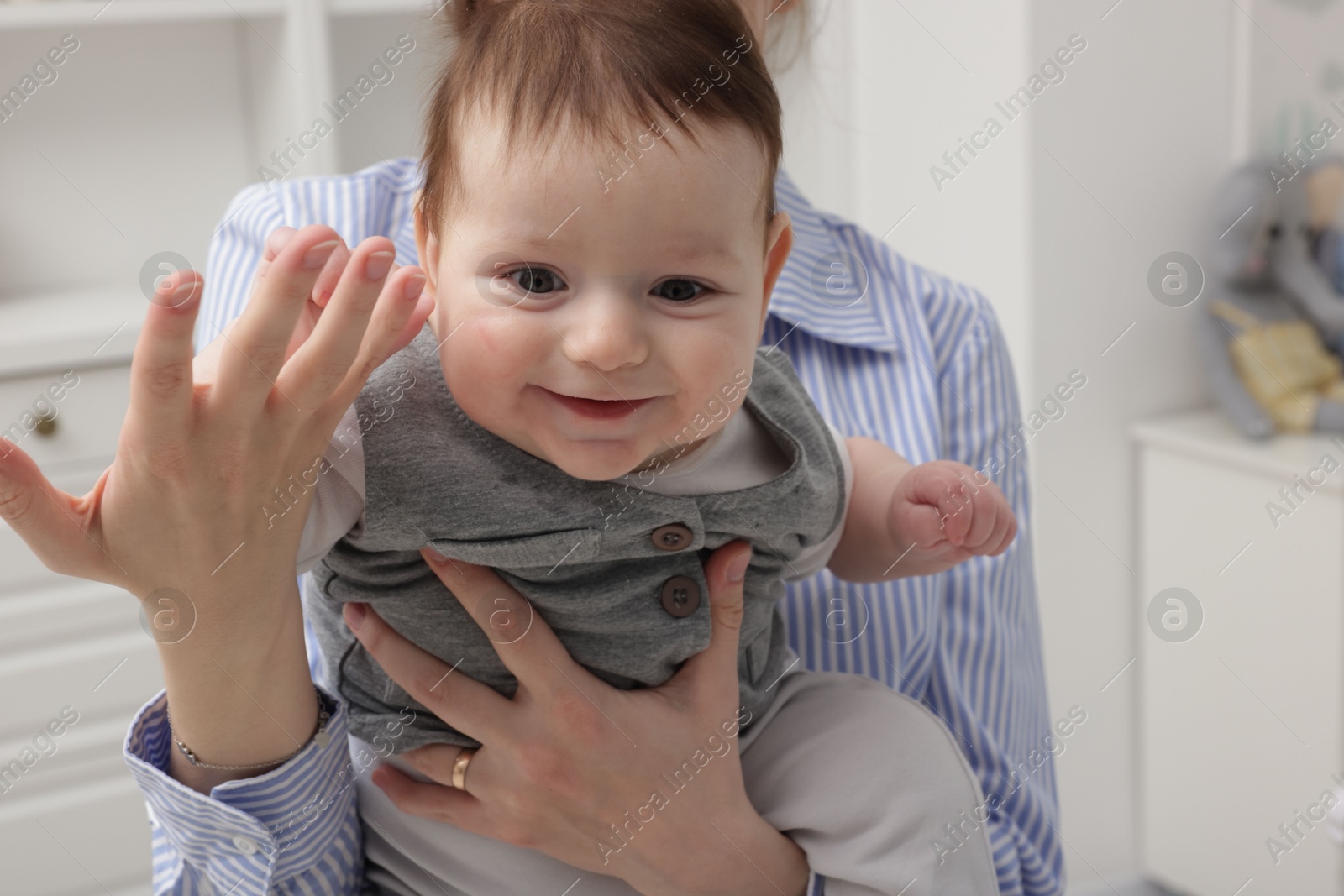 Photo of Mother holding her little baby at home, closeup