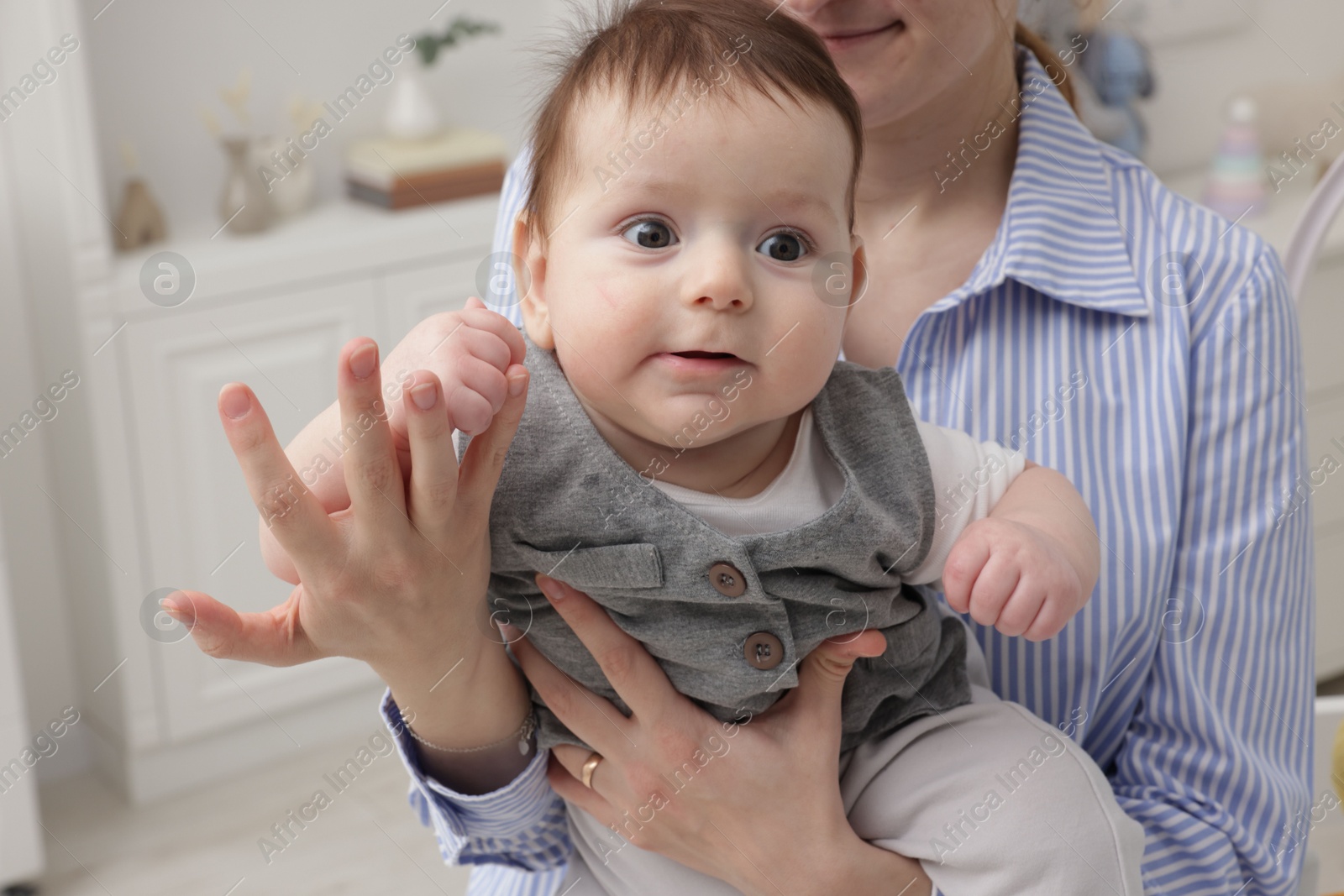 Photo of Mother holding her little baby at home, closeup