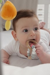 Photo of Cute little baby in crib with cot mobile at home