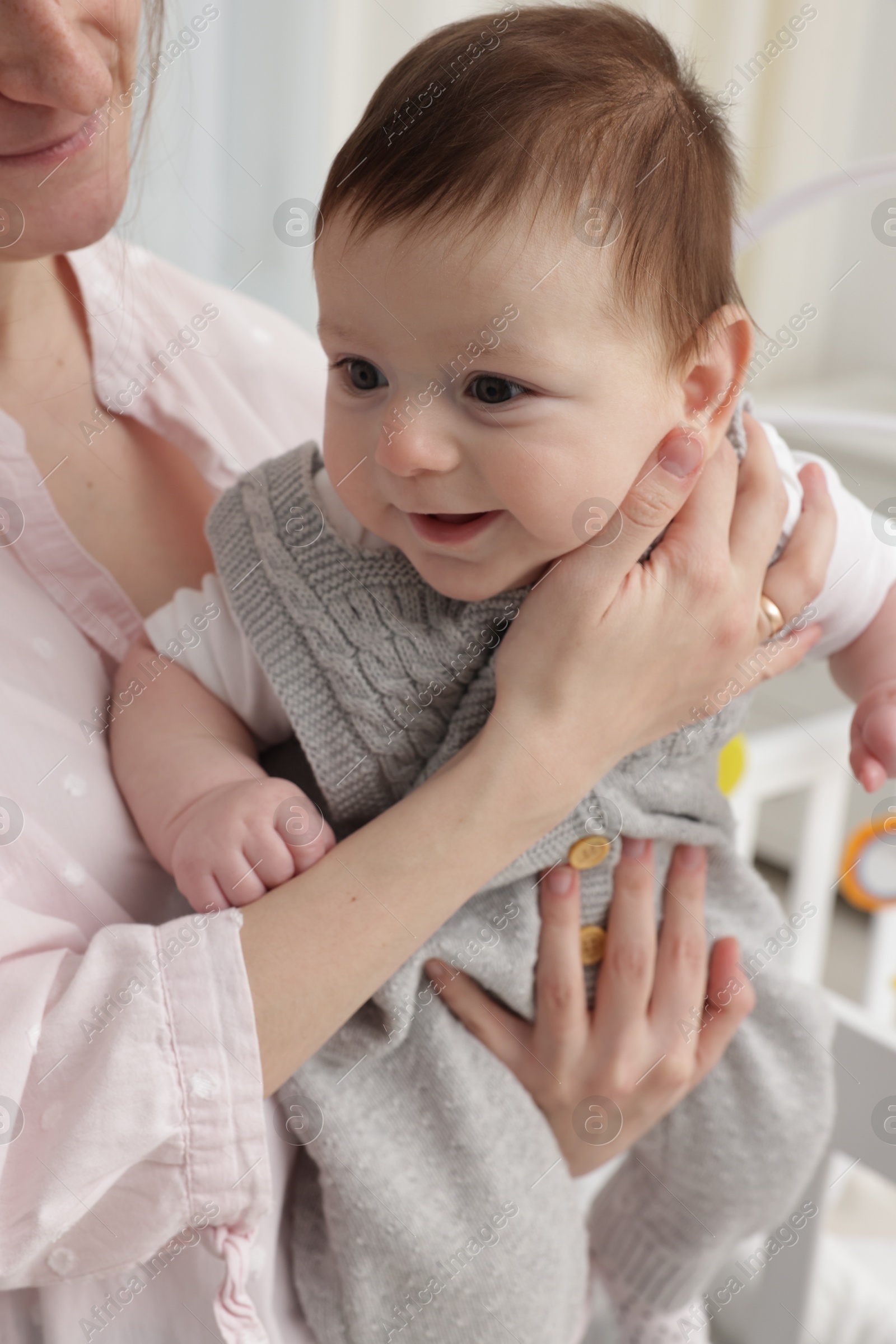 Photo of Mother holding her little baby at home, closeup