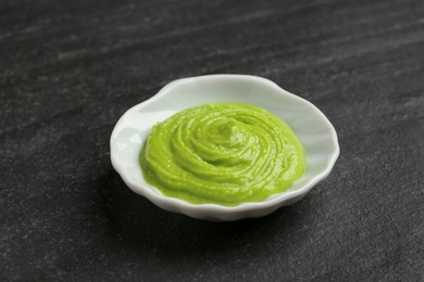 Photo of Hot wasabi paste on dark textured table, closeup