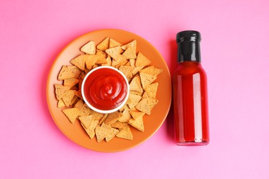 Photo of Tasty ketchup and pieces of dry bread on pink background, top view