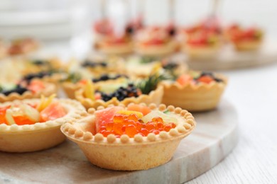 Photo of Many different tasty canapes on white wooden table, closeup