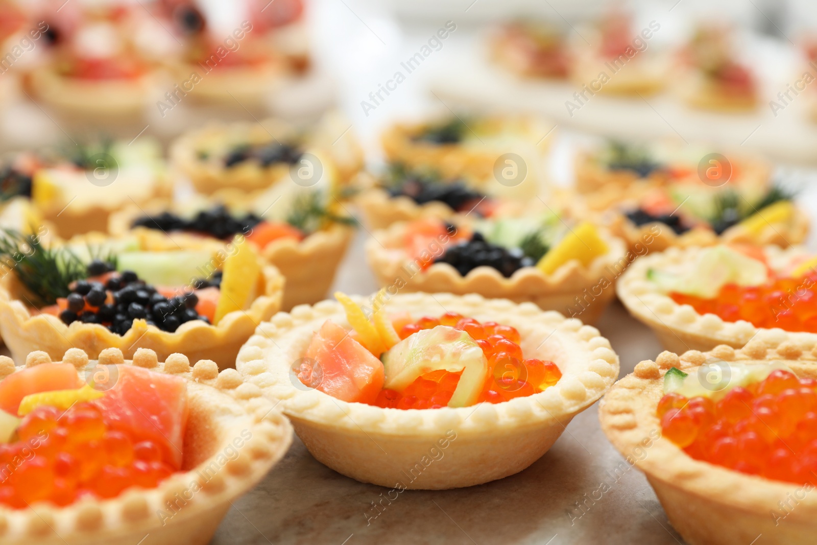 Photo of Many different tasty canapes on wooden board, closeup