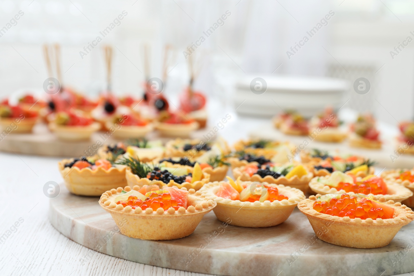 Photo of Many different tasty canapes on white wooden table, closeup