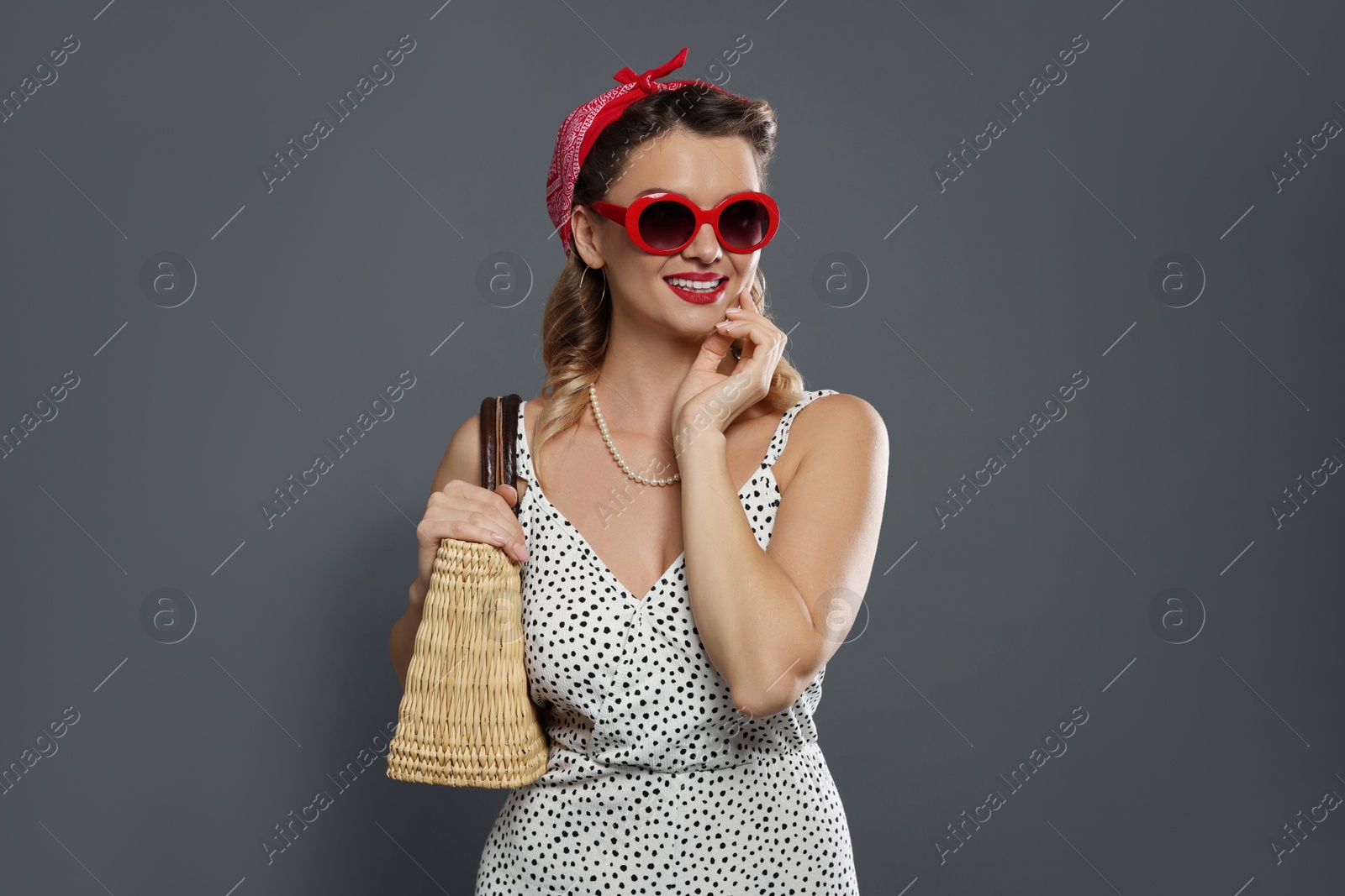 Photo of Happy pin-up woman with bag posing on grey background