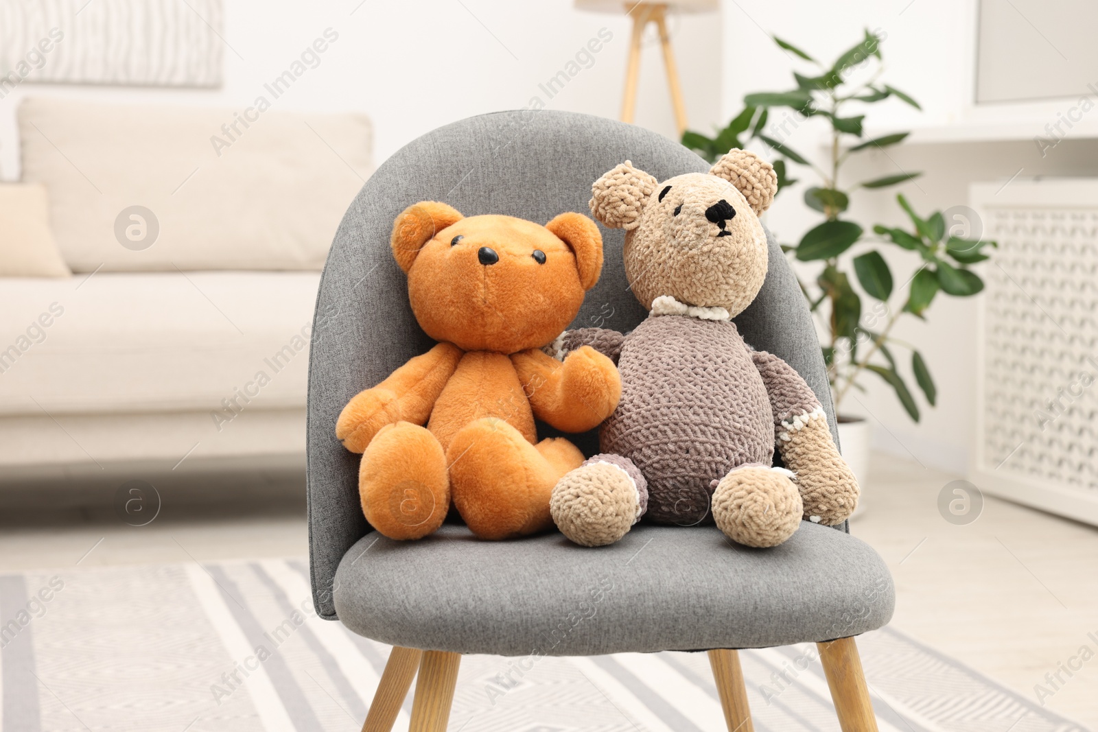 Photo of Two cute toy bears on armchair in room