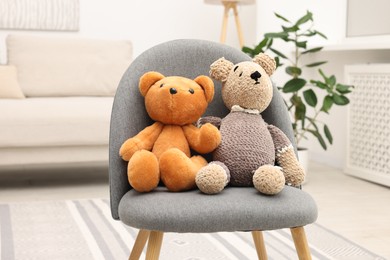 Photo of Two cute toy bears on armchair in room