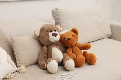 Photo of Two cute teddy bears on sofa in room