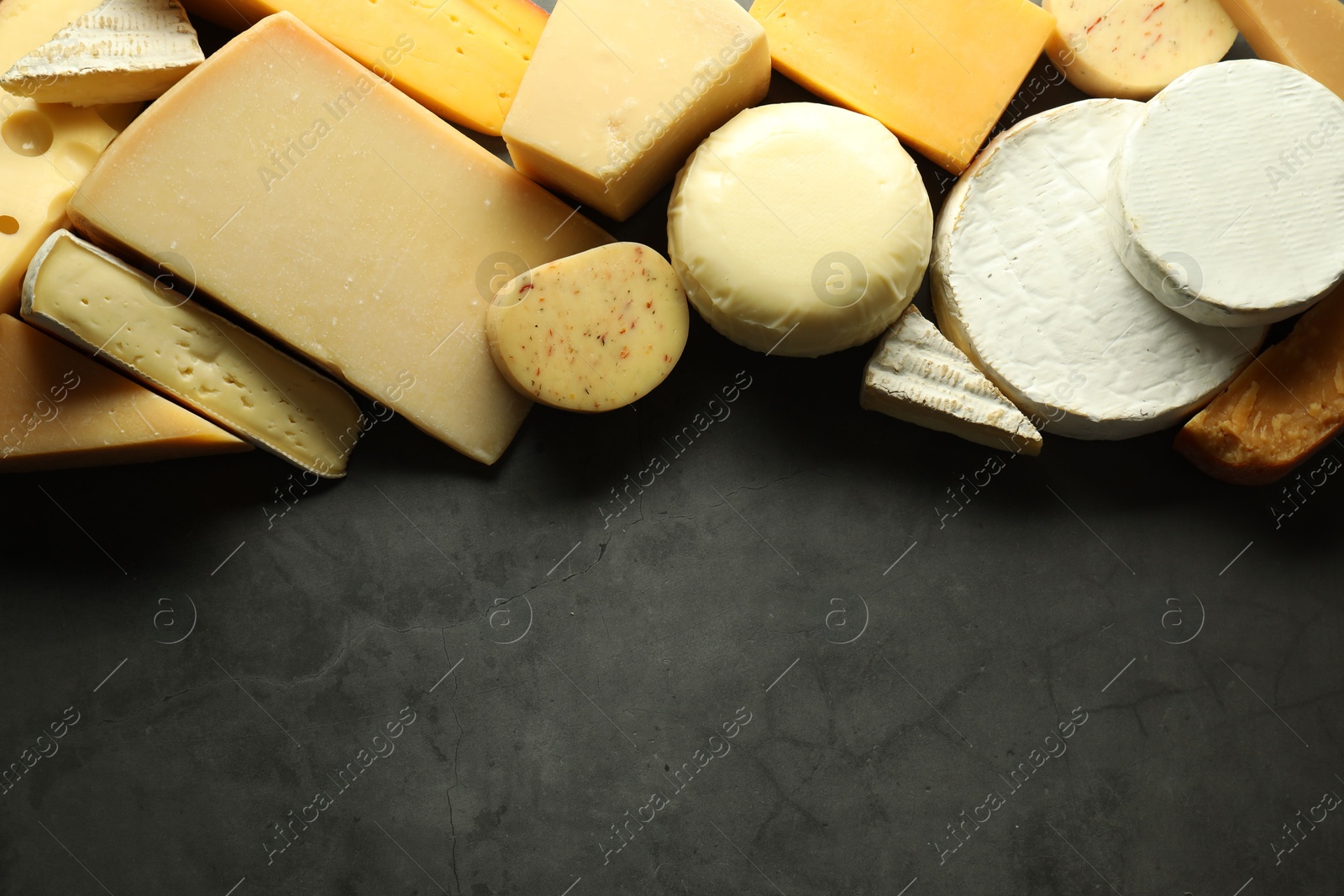 Photo of Different types of cheese on grey table, flat lay. Space for text