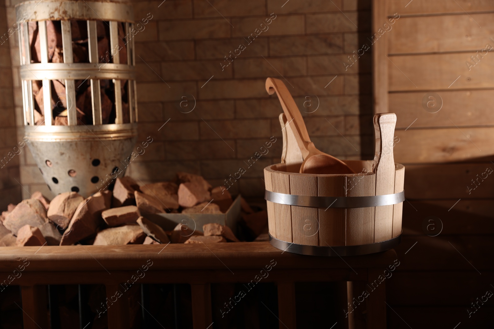 Photo of Bucket, ladle and stove with hot rocks in sauna