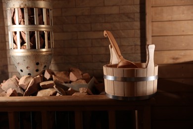 Photo of Bucket, ladle and stove with hot rocks in sauna