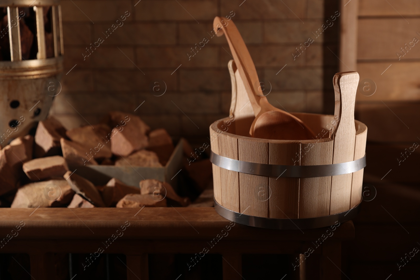 Photo of Bucket, ladle and stove with hot rocks in sauna