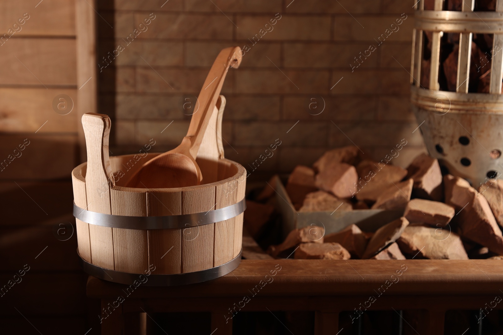 Photo of Bucket, ladle and stove with hot rocks in sauna