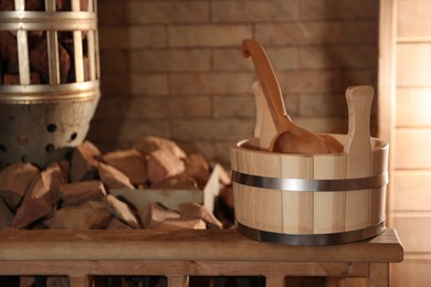 Bucket, ladle and stove with hot rocks in sauna