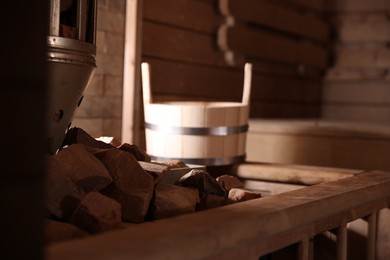 Photo of Stove with hot rocks and bucket in sauna