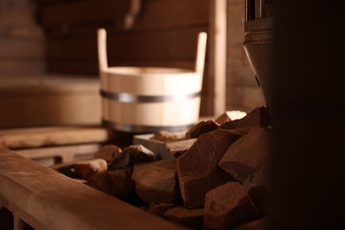 Photo of Stove with hot rocks and bucket in sauna