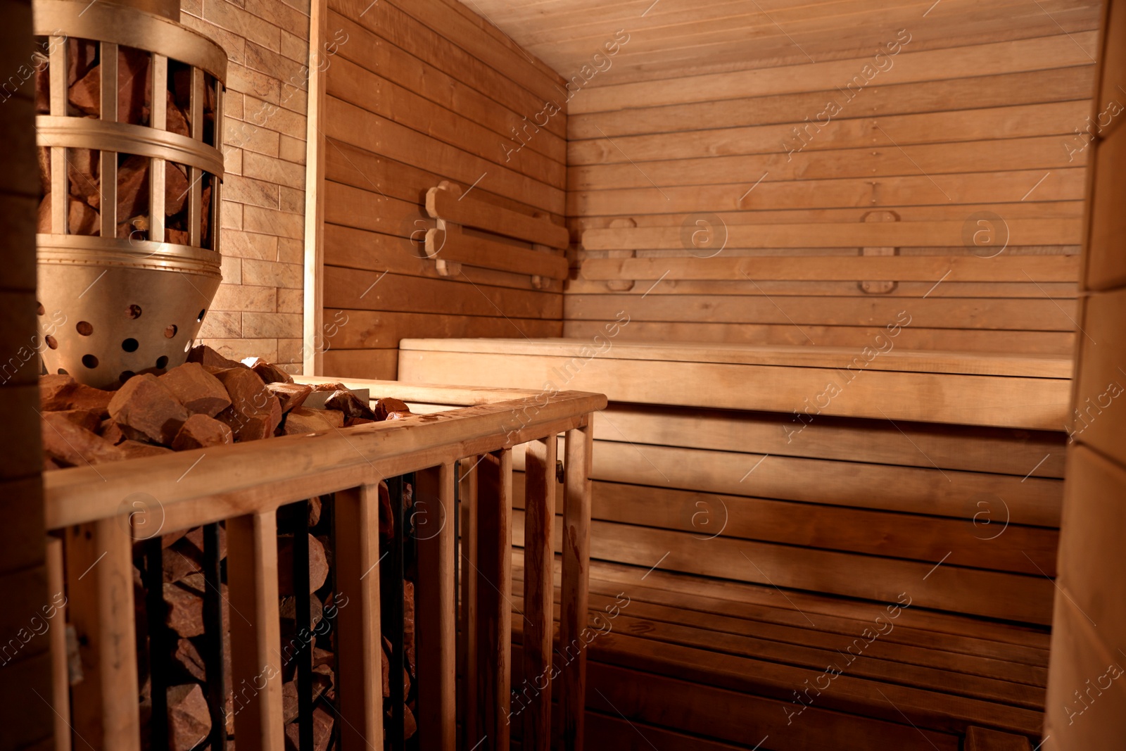 Photo of Wooden sauna with bench, stove and hot stones