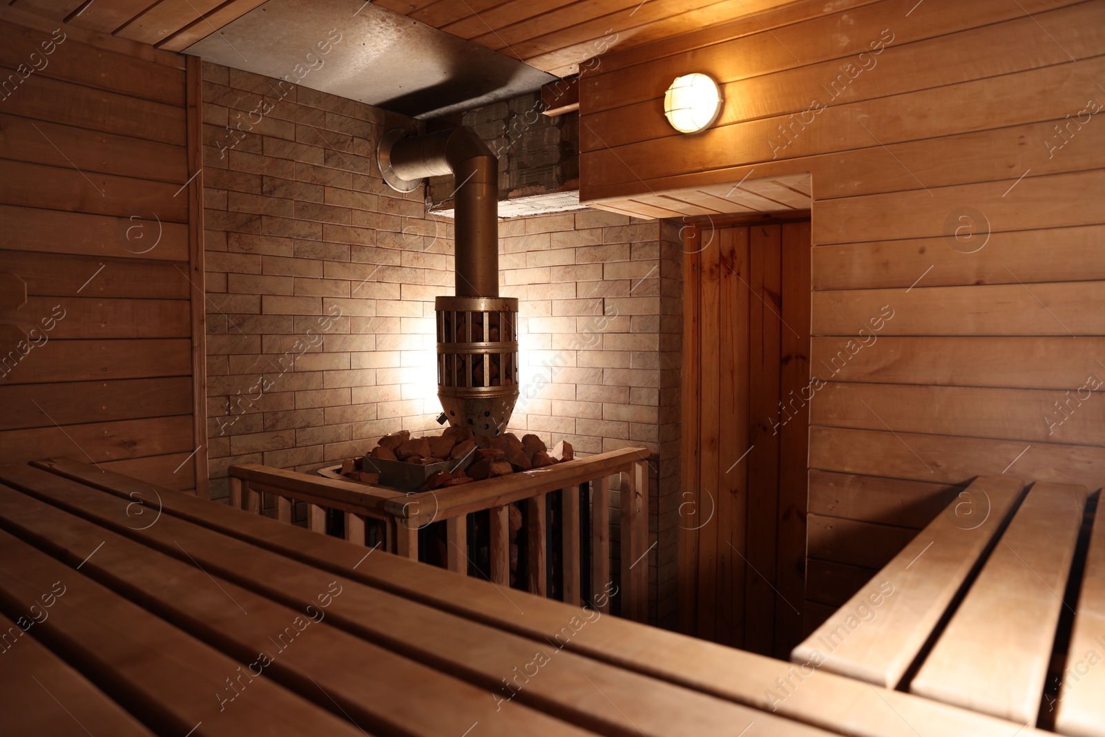 Photo of Wooden sauna with bench, stove and hot stones