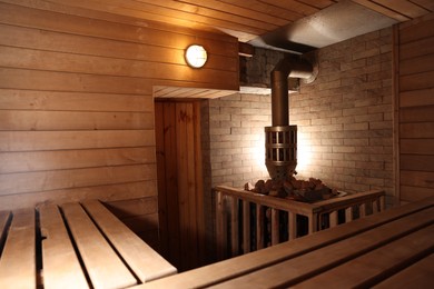 Photo of Wooden sauna with bench, stove and hot stones