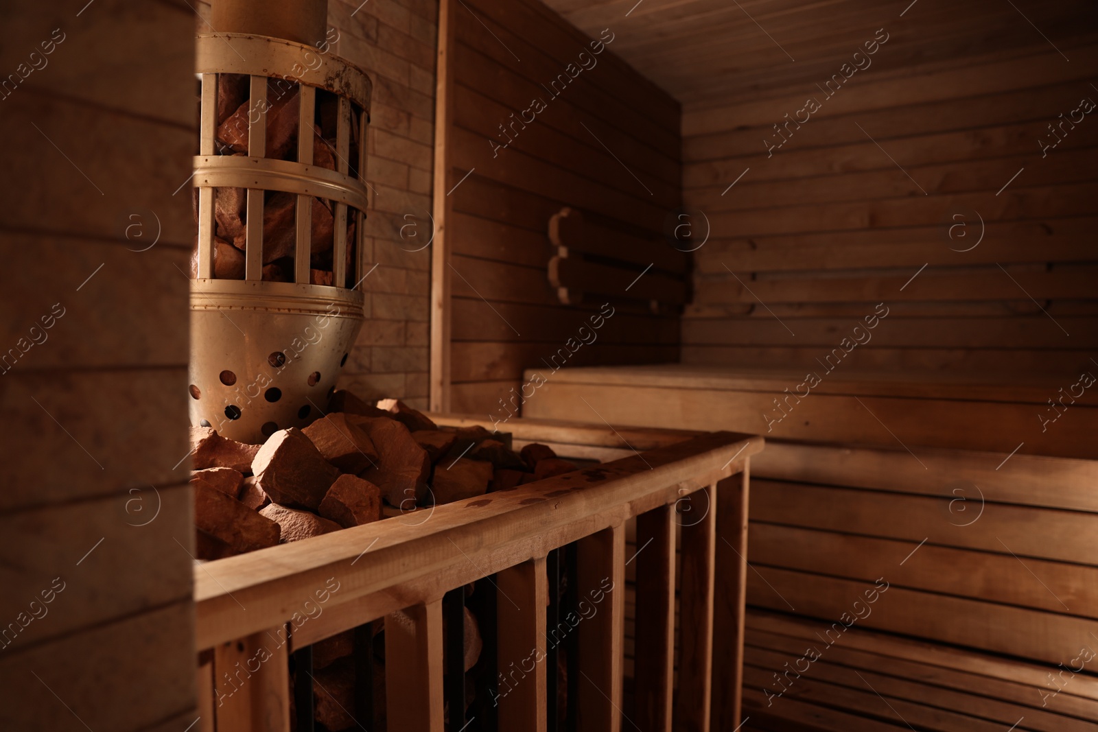 Photo of Wooden sauna with bench, stove and hot stones