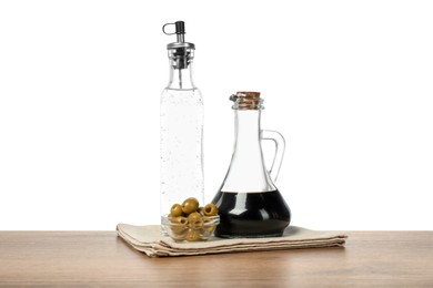 Photo of Salad dressings and olives on wooden table against white background