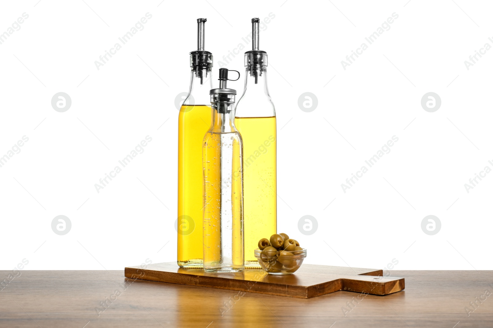 Photo of Salad dressings and olives on wooden table against white background