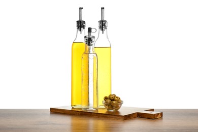 Photo of Salad dressings and olives on wooden table against white background