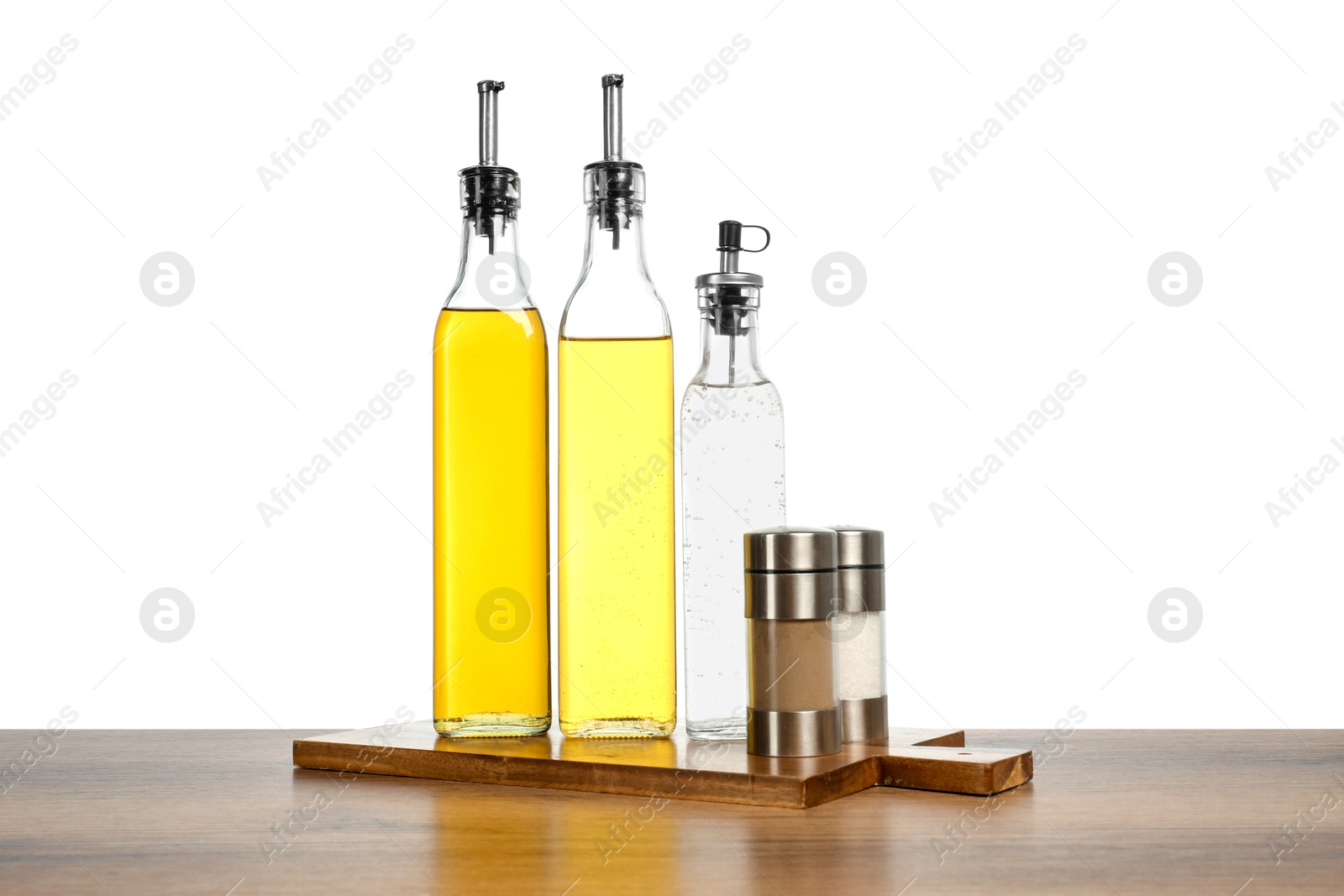 Photo of Salad dressings and spices on wooden table against white background