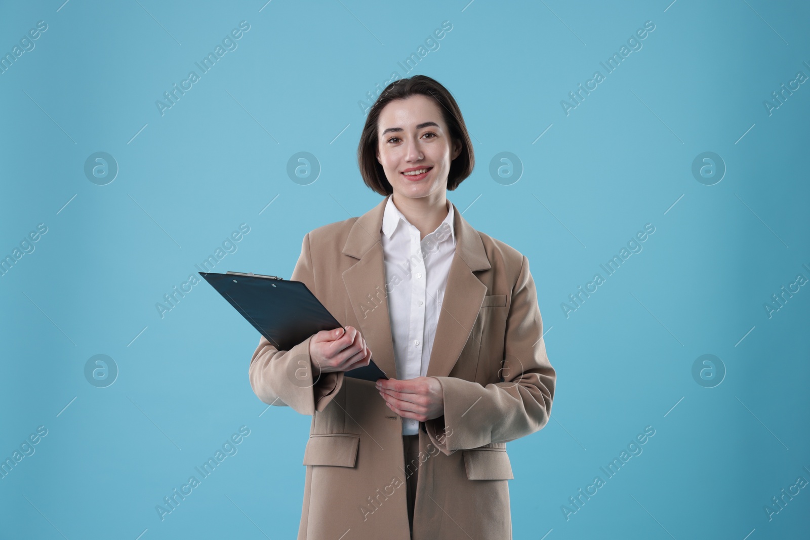 Photo of Portrait of young secretary with clipboard on light blue background