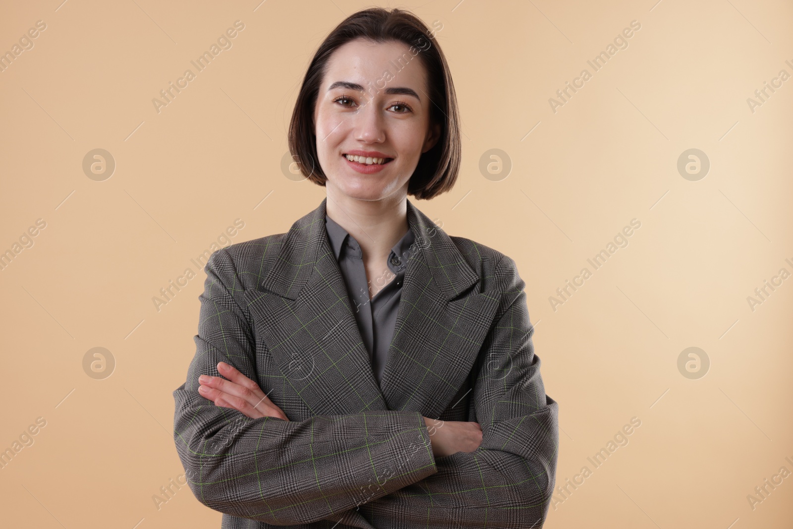 Photo of Portrait of smiling secretary against dark beige background