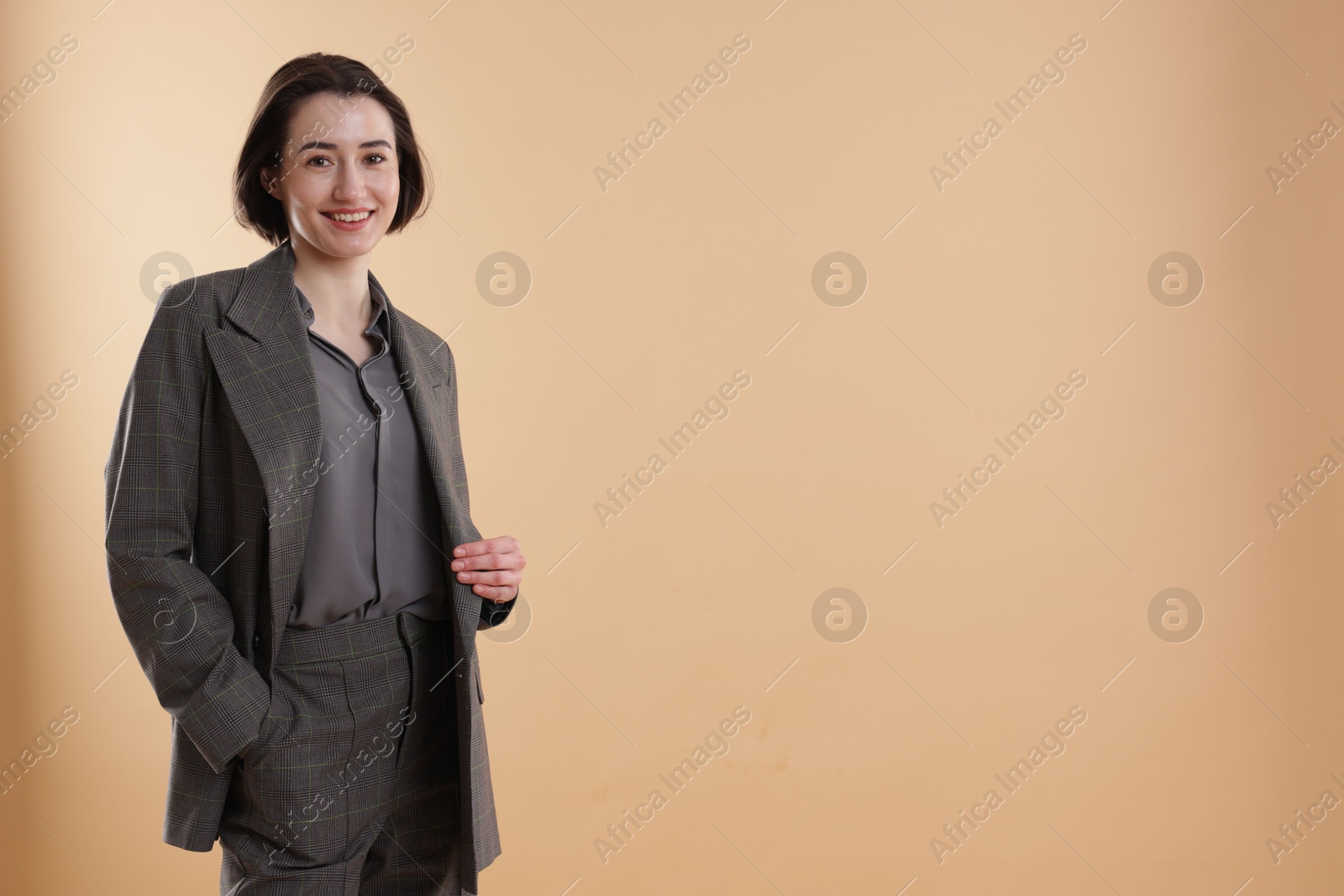 Photo of Portrait of smiling secretary against dark beige background. Space for text