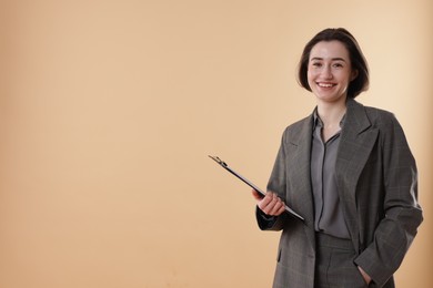 Photo of Portrait of smiling secretary with clipboard on dark beige background. Space for text