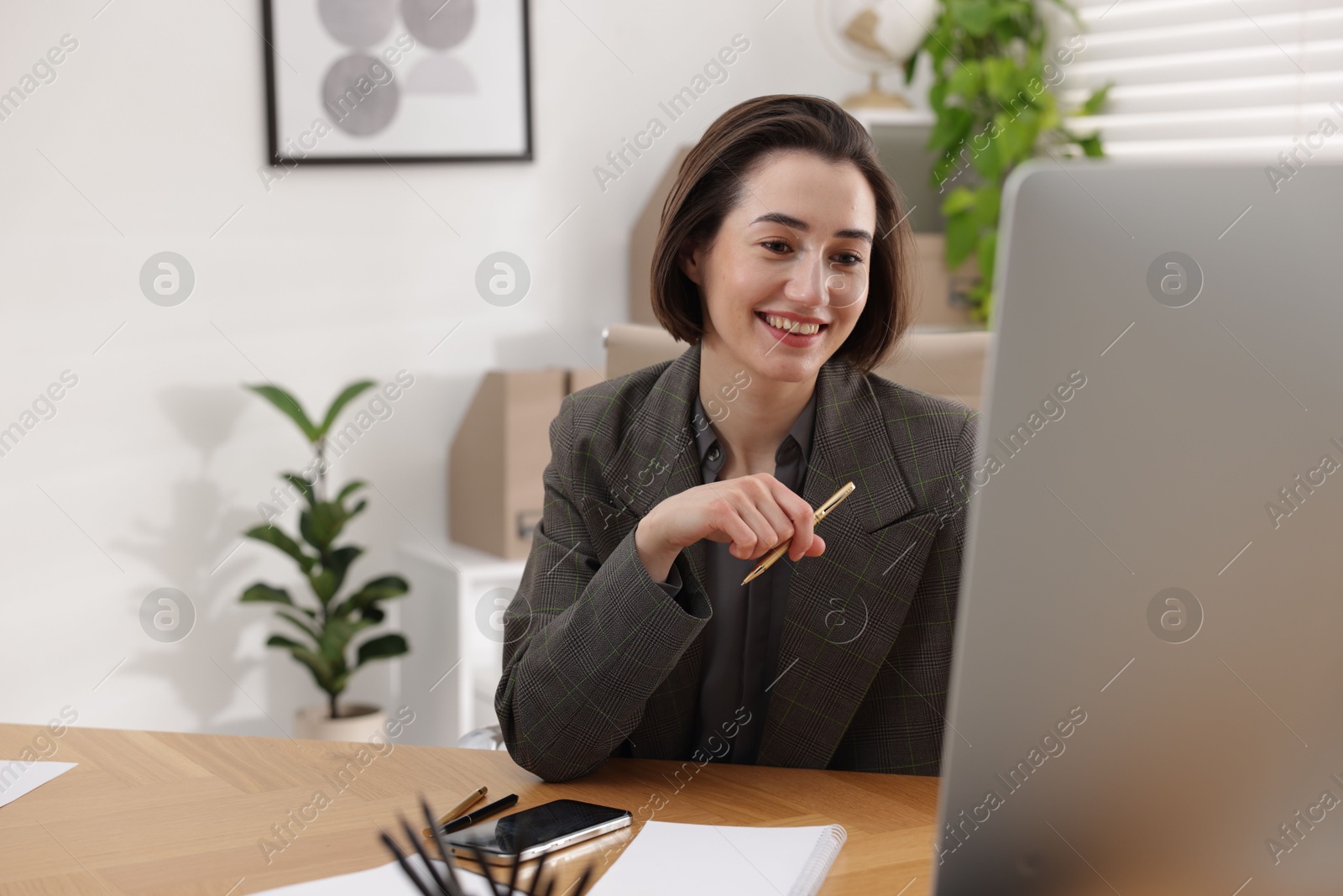 Photo of Smiling secretary working on computer at table in office