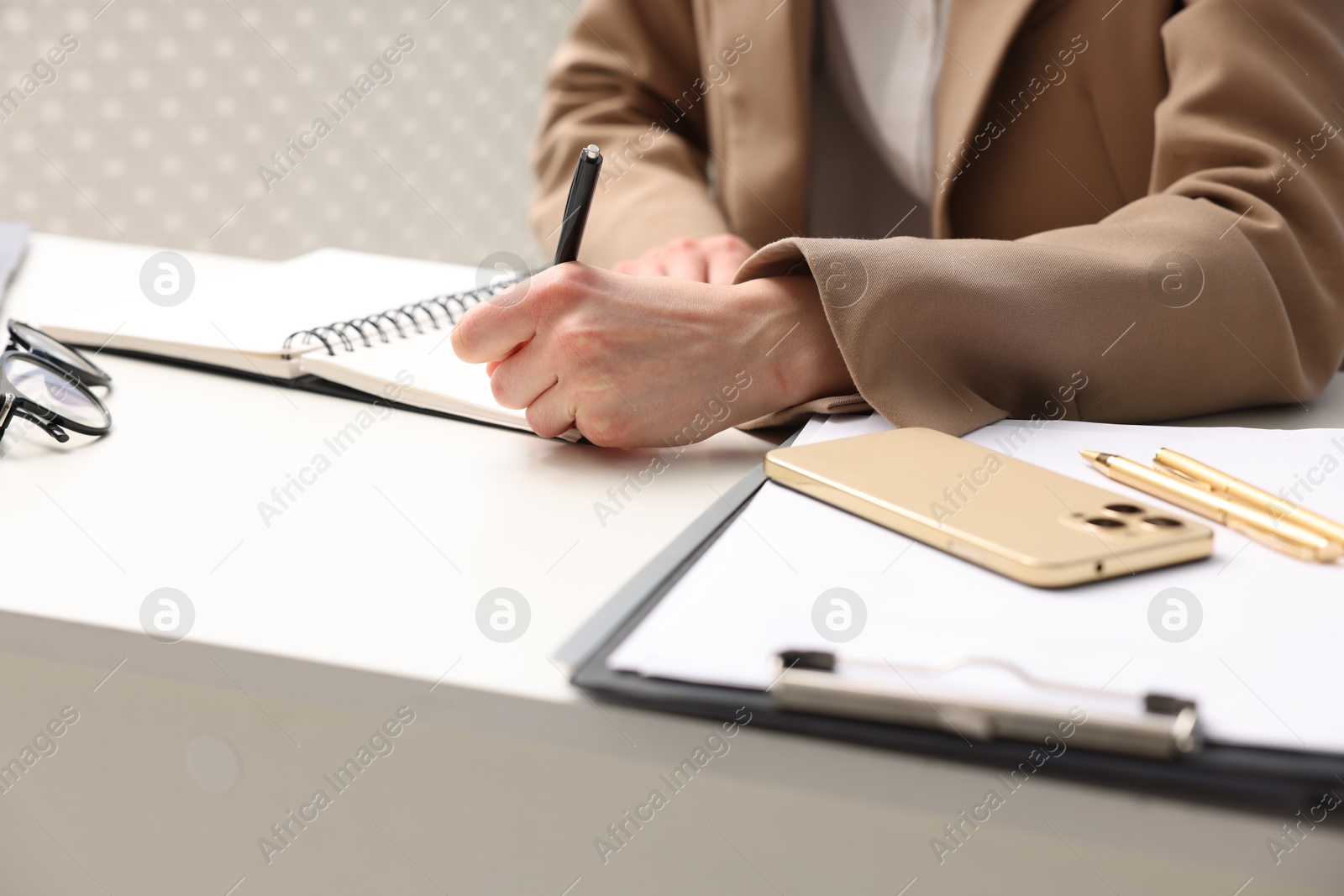 Photo of Secretary taking notes at table in office, closeup