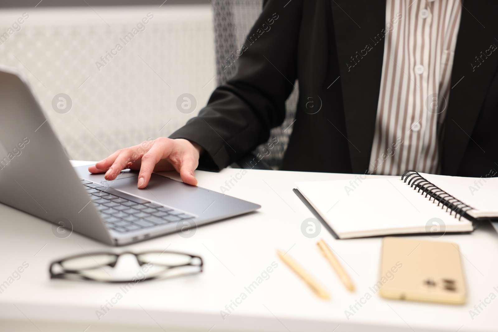 Photo of Secretary working on laptop at table in office, closeup