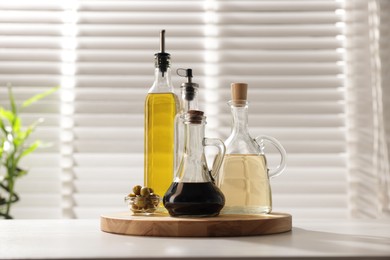 Photo of Salad dressings and olives on table in kitchen