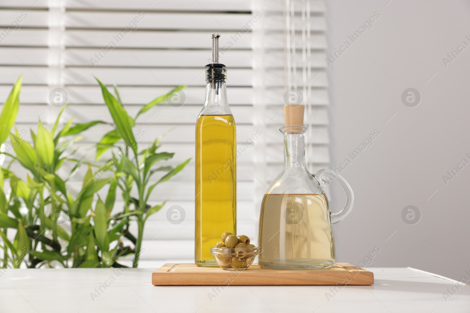 Photo of Salad dressings and olives on table in kitchen