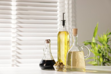 Photo of Salad dressings and olives on table in kitchen. Space for text