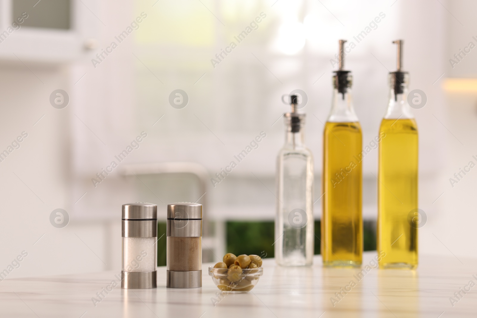 Photo of Salad dressings, spices and olives on table in kitchen. Space for text